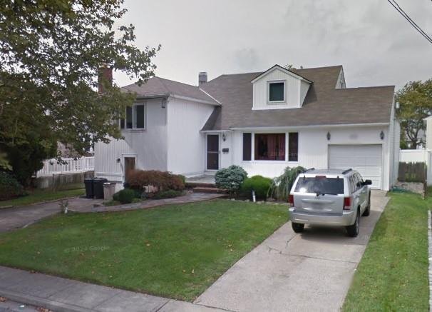 233 Harrison Ave, Island Park, NY 11558 - view of front of house with a garage, a front yard, and driveway