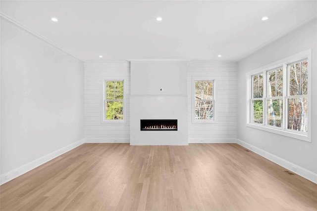 34 Old Main Rd, Quogue, NY 11959 - unfurnished living room with a warm lit fireplace, light wood-style flooring, and recessed lighting