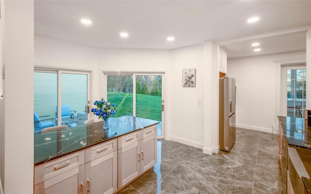 530 S Centre Island Rd, Centre Island, NY 11771 - kitchen with recessed lighting, stainless steel fridge, light marble finish floors, dark countertops, and white cabinetry