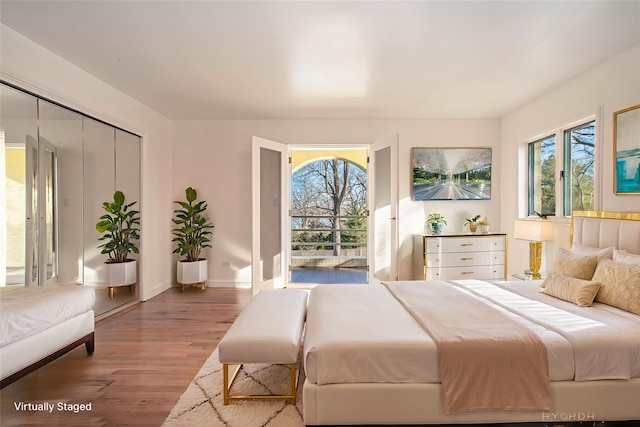 530 S Centre Island Rd, Centre Island, NY 11771 - bedroom featuring multiple windows, wood finished floors, and a closet
