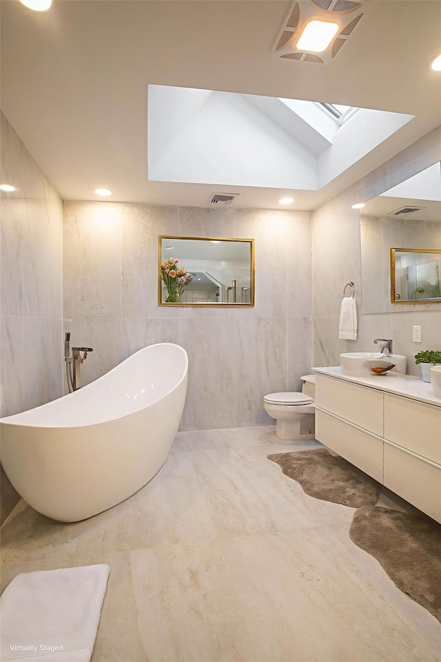 530 S Centre Island Rd, Centre Island, NY 11771 - full bath featuring tile walls, a freestanding bath, vanity, a skylight, and marble finish flooring