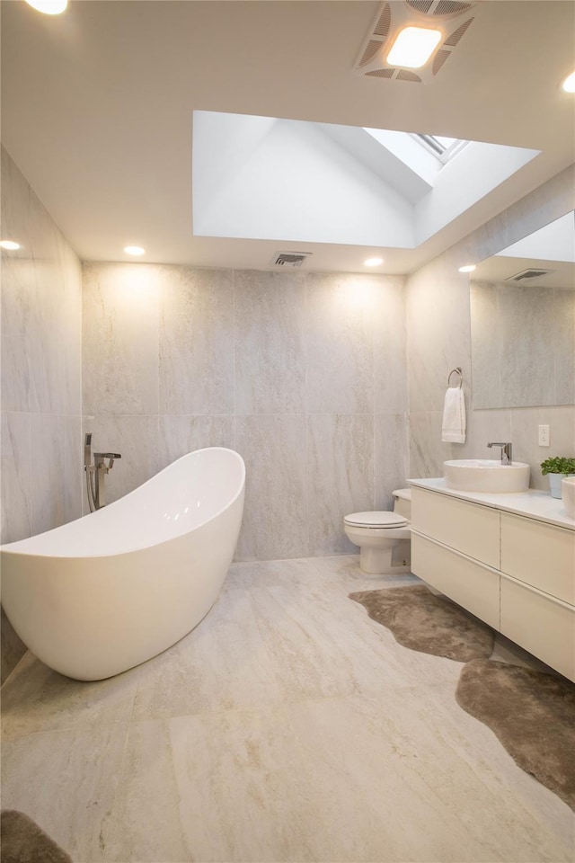 530 S Centre Island Rd, Centre Island, NY 11771 - bathroom featuring tile walls, vanity, a freestanding bath, and a skylight