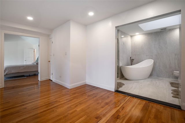 530 S Centre Island Rd, Centre Island, NY 11771 - full bathroom featuring a skylight, a freestanding bath, wood finished floors, ensuite bath, and recessed lighting