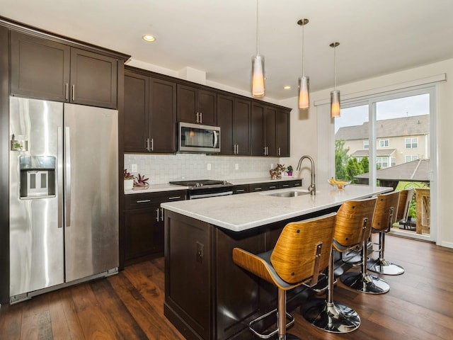 57 Lewis Rd, Hopewell Junction, NY 12533 - kitchen featuring stainless steel appliances, dark wood-style floors, dark brown cabinets, tasteful backsplash, and a kitchen bar