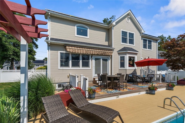 565 S 8th St, Lindenhurst, NY 11757 - back of property with a wooden deck and outdoor dining area