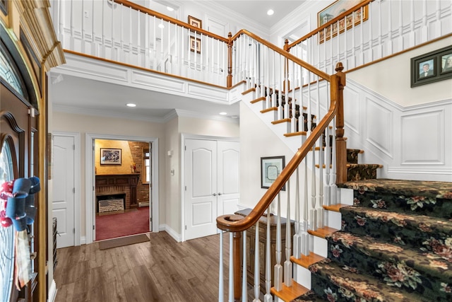 565 S 8th St, Lindenhurst, NY 11757 - foyer entrance featuring a high ceiling, stairway, ornamental molding, wood finished floors, and recessed lighting