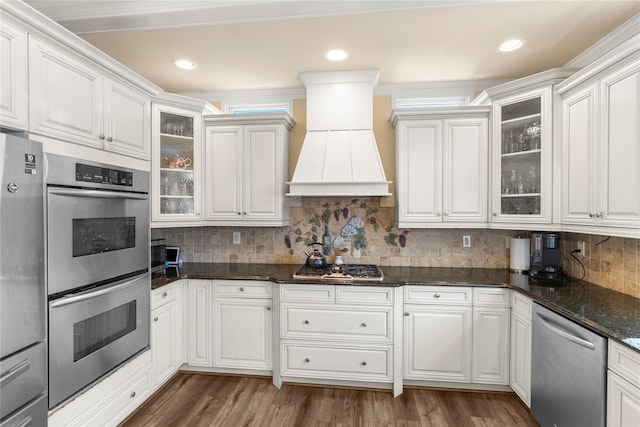 565 S 8th St, Lindenhurst, NY 11757 - kitchen with appliances with stainless steel finishes, glass insert cabinets, wood finished floors, decorative backsplash, and recessed lighting