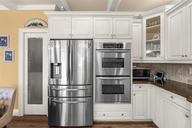 565 S 8th St, Lindenhurst, NY 11757 - kitchen with stainless steel appliances, ornamental molding, glass insert cabinets, decorative backsplash, and dark wood finished floors