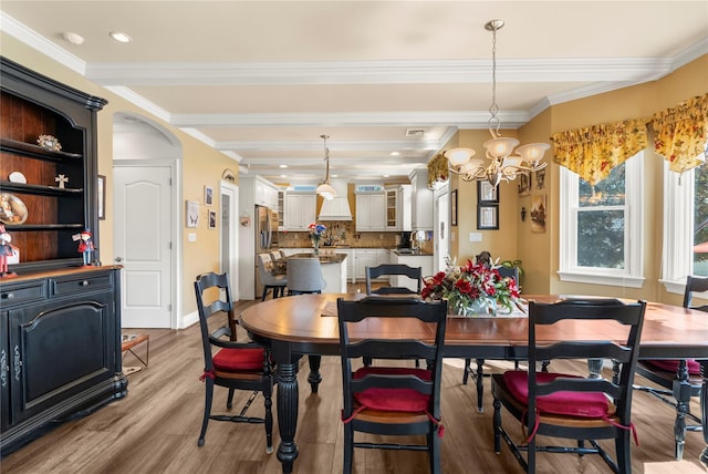 565 S 8th St, Lindenhurst, NY 11757 - dining area with wood finished floors, crown molding, a chandelier, arched walkways, and recessed lighting