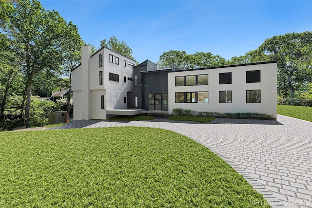 12 Plume Grass Way, Westhampton, NY 11977 - view of front facade with a front yard, driveway, and stucco siding