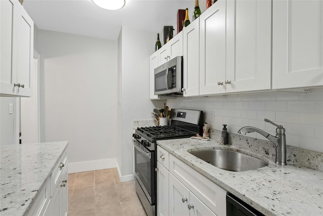 37 Central Ave Unit 2G, Hartsdale, NY 10530 - kitchen featuring stainless steel appliances, backsplash, white cabinets, and light stone counters