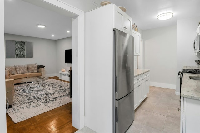 37 Central Ave Unit 2G, Hartsdale, NY 10530 - kitchen with appliances with stainless steel finishes, white cabinets, light stone countertops, open floor plan, and recessed lighting