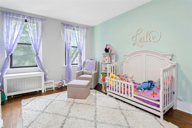 37 Central Ave Unit 2G, Hartsdale, NY 10530 - bedroom featuring radiator, a crib, and wood finished floors