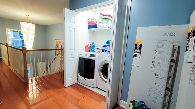 948 Orlando Ave, West Hempstead, NY 11552 - laundry area with washer and dryer, light wood finished floors, and a chandelier