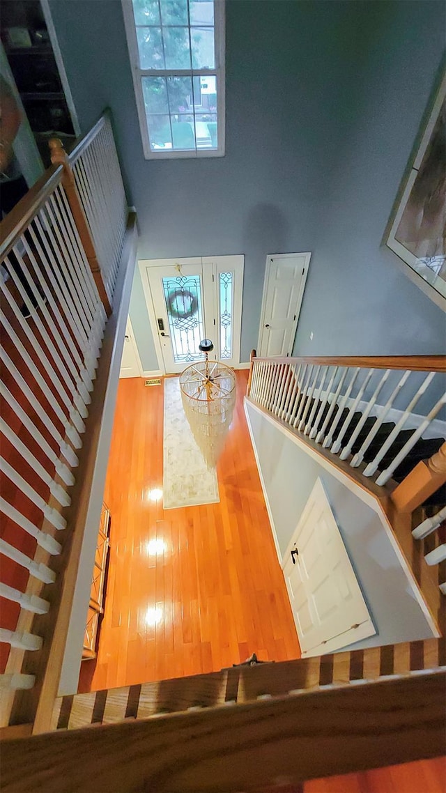 948 Orlando Ave, West Hempstead, NY 11552 - stairway featuring wood finished floors, a high ceiling, and a chandelier