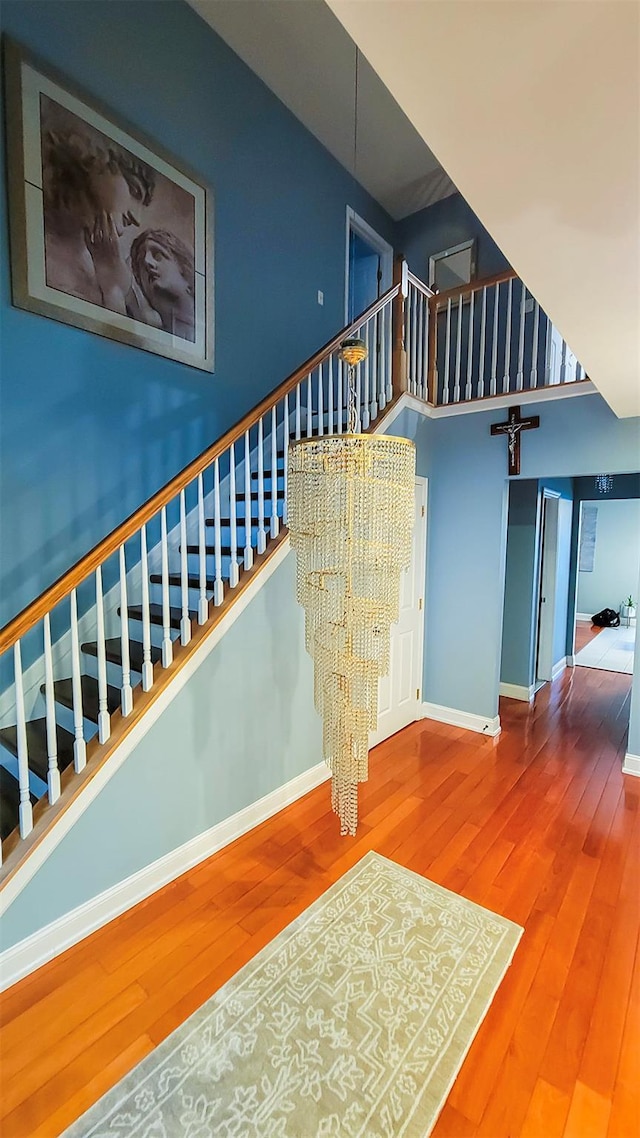 948 Orlando Ave, West Hempstead, NY 11552 - stairs featuring wood finished floors, a chandelier, and a towering ceiling