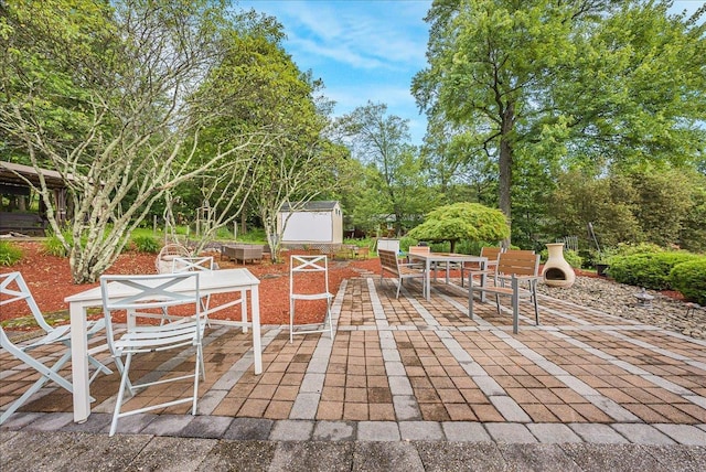 48 Eastview Rd, Highland Mills, NY 10930 - view of patio featuring a storage shed, outdoor dining area, and view of wooded area