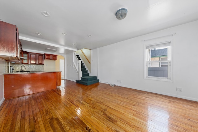 117-66 127th St, South Ozone Park, NY 11420 - unfurnished living room with hardwood / wood-style flooring, arched walkways, and stairs
