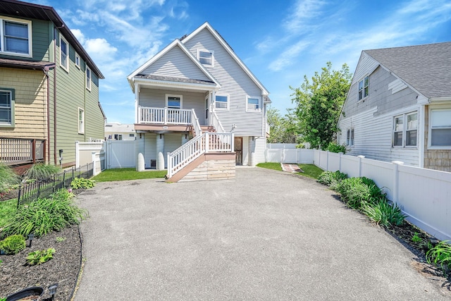 43 E Jackson Ave, Babylon, NY 11702 - back of property featuring asphalt driveway, stairway, and a fenced backyard