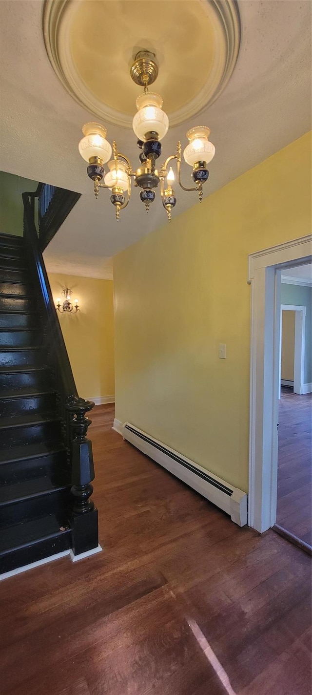 5-7 Myrtle Ave, Pine Plains, NY 12567 - stairway featuring a baseboard radiator, wood finished floors, a chandelier, a tray ceiling, and ornamental molding