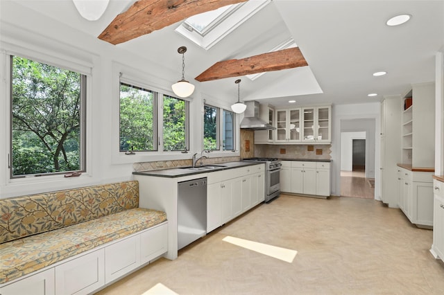 383 Pine Brook Rd, Bedford, NY 10506 - kitchen featuring stainless steel appliances, a skylight, wall chimney range hood, decorative backsplash, and white cabinetry
