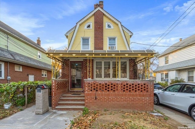 100-56 223rd St, Queens Village, NY 11429 - colonial inspired home featuring a gambrel roof, brick siding, and a chimney