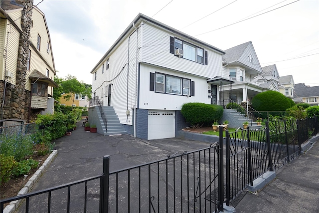 112 N Columbus Ave, Mount Vernon, NY 10553 - view of front facade with driveway, a garage, stairs, a residential view, and a fenced front yard
