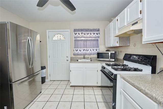112 N Columbus Ave, Mount Vernon, NY 10553 - kitchen featuring appliances with stainless steel finishes, under cabinet range hood, light tile patterned flooring, and white cabinets