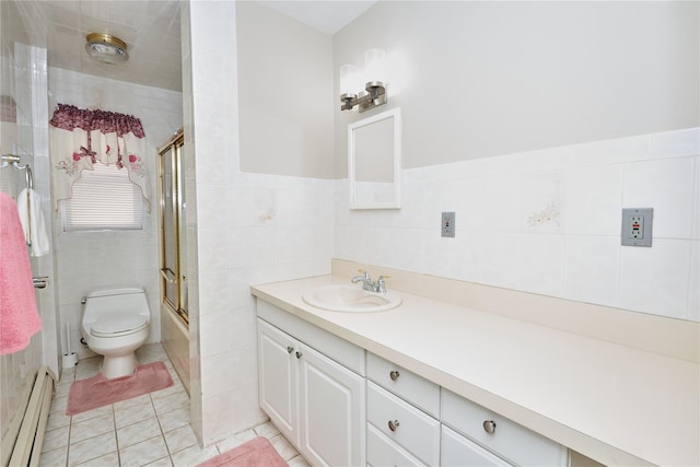 112 N Columbus Ave, Mount Vernon, NY 10553 - bathroom with a baseboard radiator, tile walls, vanity, shower / bath combination with glass door, and tile patterned floors