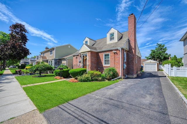 31 Pilgrim St, New Hyde Park, NY 11040 - view of front facade with brick siding, driveway, a chimney, a detached garage, and an outdoor structure