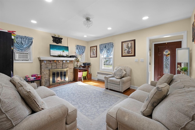 31 Pilgrim St, New Hyde Park, NY 11040 - living area featuring radiator, wood finished floors, a stone fireplace, and recessed lighting