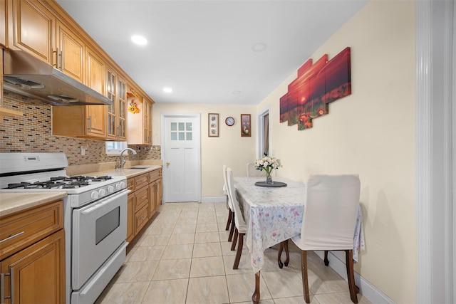 31 Pilgrim St, New Hyde Park, NY 11040 - kitchen featuring white range with gas stovetop, under cabinet range hood, decorative backsplash, light countertops, and recessed lighting