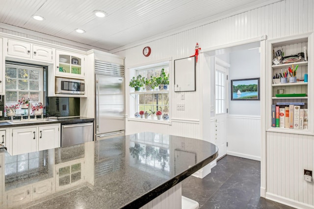 537 Moriches Rd, Head Of The Harbor, NY 11780 - kitchen featuring appliances with stainless steel finishes, dark marble finish flooring, white cabinets, wainscoting, and crown molding