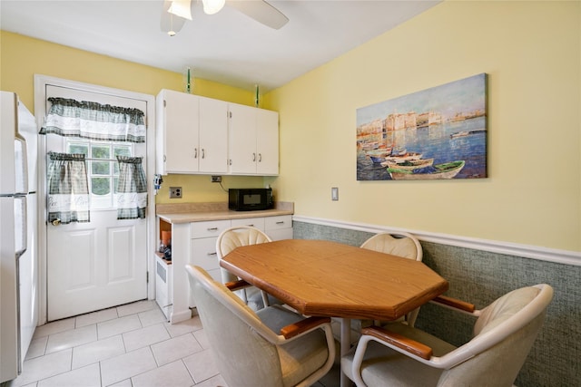 6 Vermont St, Lindenhurst, NY 11757 - dining room featuring a ceiling fan, light tile patterned flooring, and wainscoting