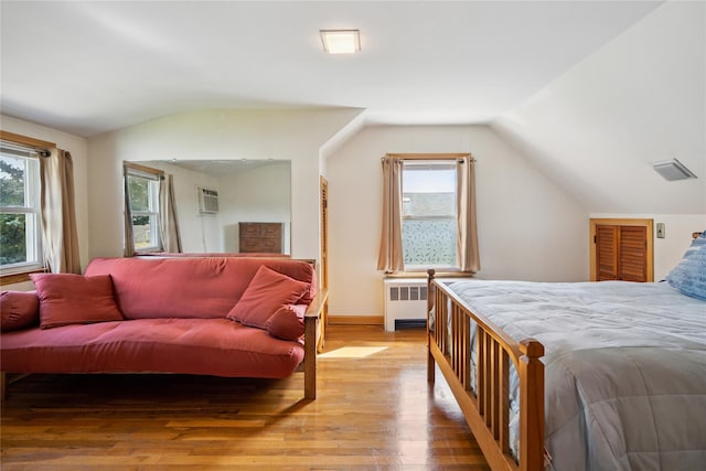 6 Vermont St, Lindenhurst, NY 11757 - bedroom featuring vaulted ceiling, radiator, light wood-style floors, and a wall mounted air conditioner