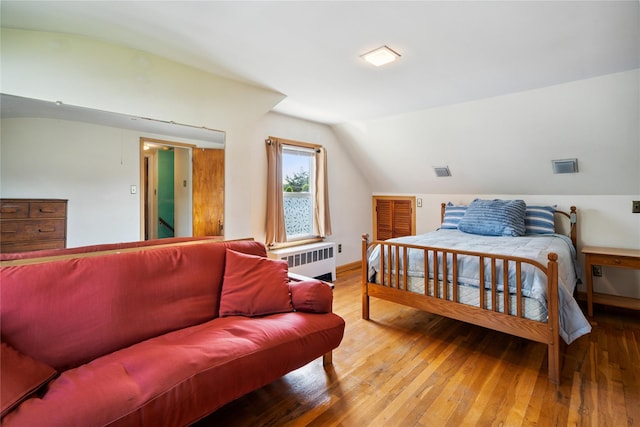 6 Vermont St, Lindenhurst, NY 11757 - bedroom with radiator heating unit, vaulted ceiling, and hardwood / wood-style floors