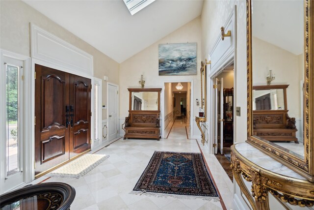 10 Laurel Woods Dr, Upper Brookville, NY 11771 - entrance foyer with high vaulted ceiling, wainscoting, a skylight, and a decorative wall