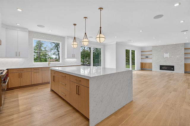 32A Pine Rd, Syosset, NY 11791 - kitchen featuring light wood finished floors, a center island, modern cabinets, light stone counters, and tasteful backsplash