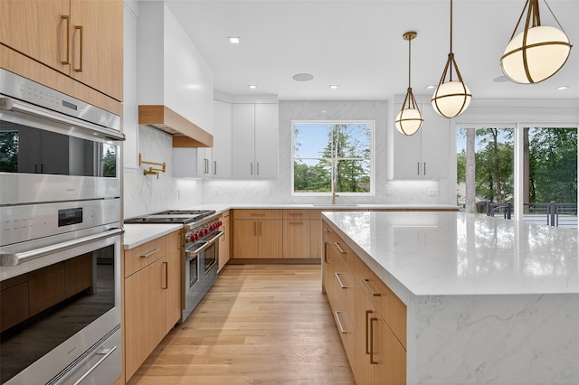 32A Pine Rd, Syosset, NY 11791 - kitchen featuring appliances with stainless steel finishes, custom range hood, light wood-style flooring, tasteful backsplash, and light stone counters