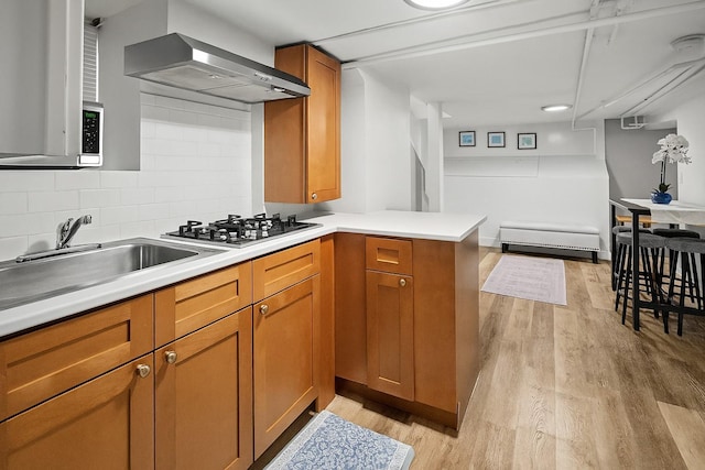 51 Lincoln St, New Rochelle, NY 10801 - kitchen with wall chimney exhaust hood, stainless steel gas stovetop, light wood-type flooring, and light countertops