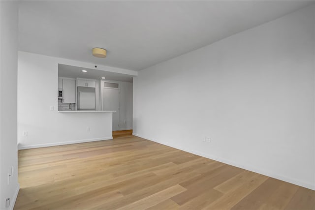 635 W 42nd St Unit 7A, New York Manhattan, NY 10036 - unfurnished living room with light wood-style floors and recessed lighting