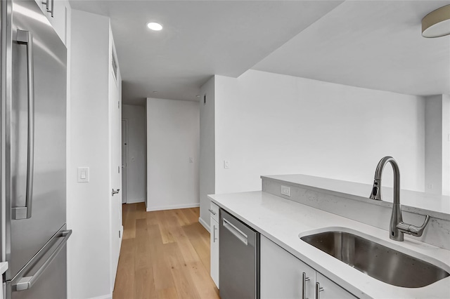 635 W 42nd St Unit 7A, New York Manhattan, NY 10036 - kitchen with appliances with stainless steel finishes, white cabinetry, recessed lighting, and light wood finished floors