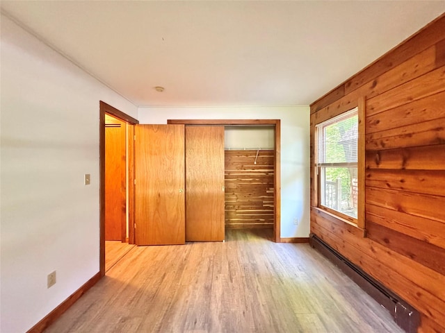 5 Will Palmer Rd, Catskill, NY 12414 - unfurnished bedroom with a baseboard radiator, wood finished floors, a closet, and wood walls