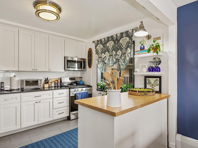 666 Pelham Rd Unit 3N, New Rochelle, NY 10805 - kitchen with stainless steel appliances, wood counters, white cabinetry, and decorative backsplash