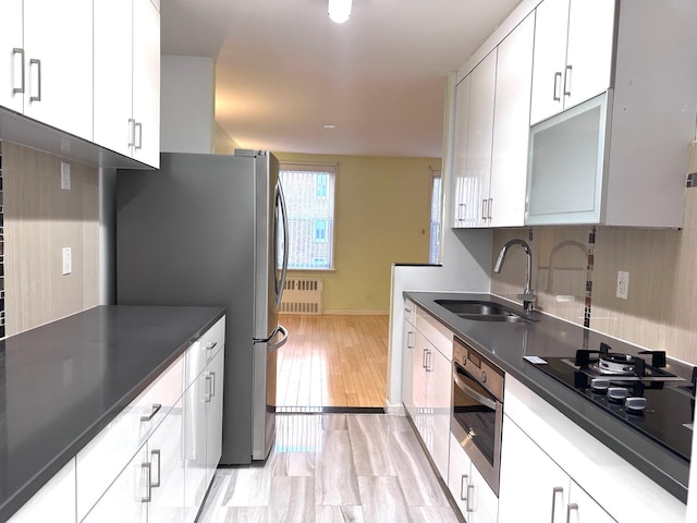 142-05 Roosevelt Ave Unit 415, Flushing, NY 11354 - kitchen featuring radiator heating unit, appliances with stainless steel finishes, dark countertops, and white cabinets