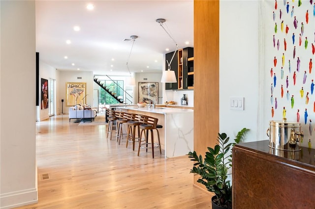 11 Lawrence Ln, Palisades, NY 10964 - kitchen with light wood-style flooring, a breakfast bar, a kitchen island with sink, and recessed lighting
