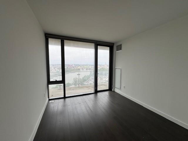 13105 40th Rd Unit 15E, Flushing, NY 11354 - spare room with expansive windows, dark wood finished floors, and a water view