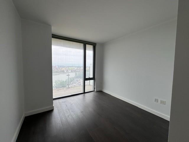 13105 40th Rd Unit 15E, Flushing, NY 11354 - empty room with dark wood-type flooring and a wall of windows