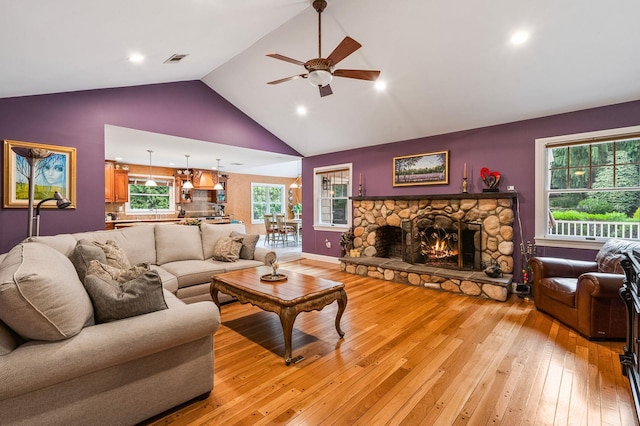 14 Etna Ln, Dix Hills, NY 11746 - living room featuring ceiling fan, light wood finished floors, a fireplace, high vaulted ceiling, and plenty of natural light
