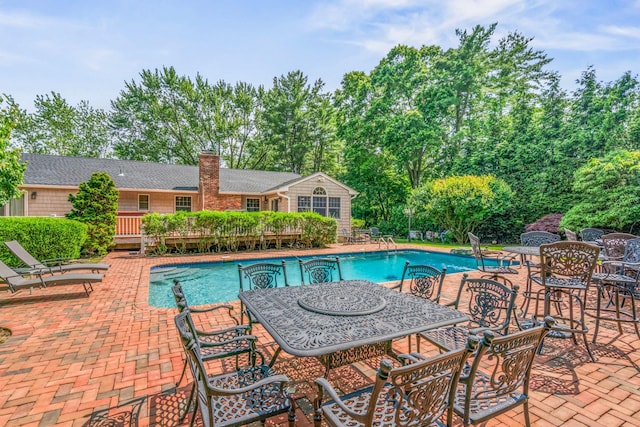 14 Etna Ln, Dix Hills, NY 11746 - swimming pool featuring a patio area, outdoor dining area, and view of scattered trees